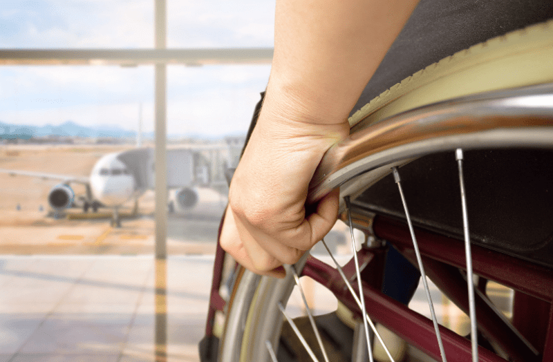 A man in a wheelchair considering how the plane he is about to travel on can better adapt for people with disabilities. 
