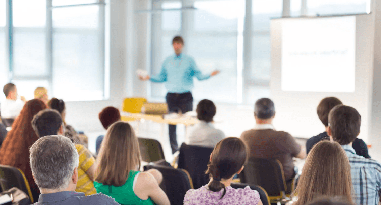 Business meeting full of people in a meeting room pre-covid