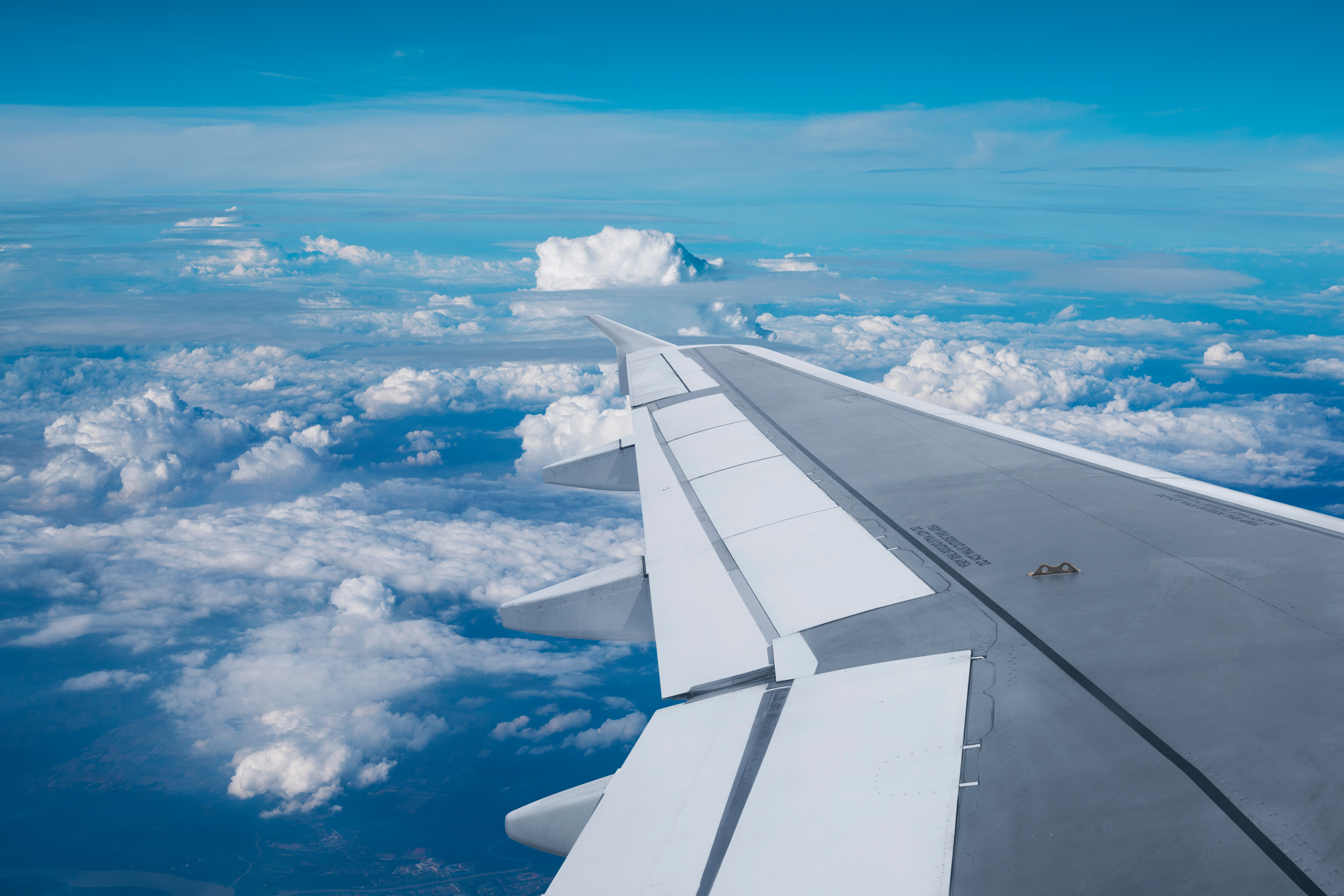 A plane wing with a blue sky and clouds in the background to show how automation is helping the skills shortage in American TMCs