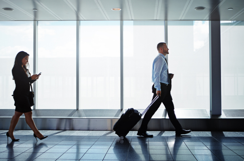 A man walking through an airport going to a business conference