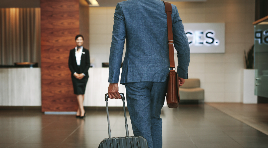 A man with a suitcase representing travel managers